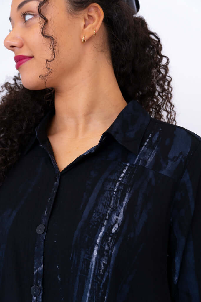 Close-up of collar and button details on black patterned top