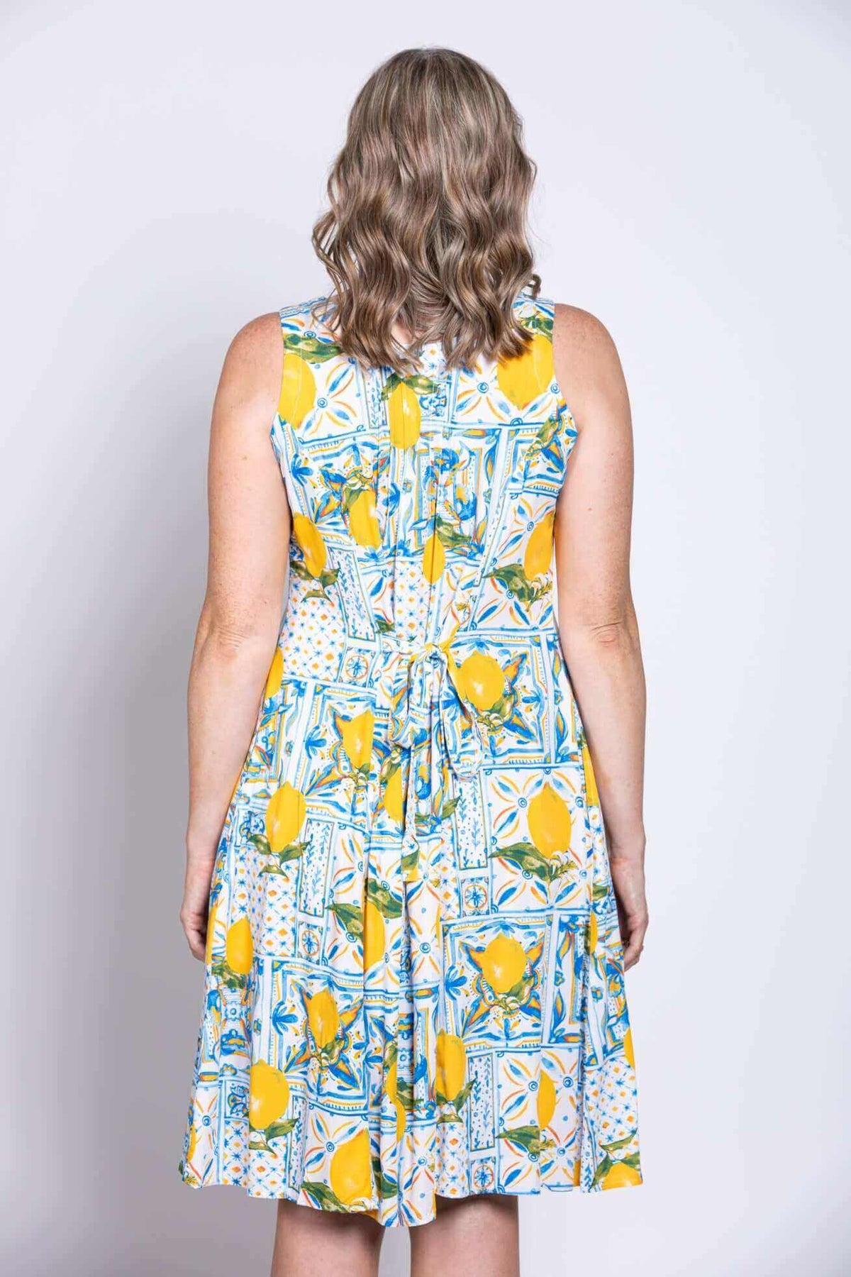 Close-up back view of dress showing tie-back detail and lemon print design