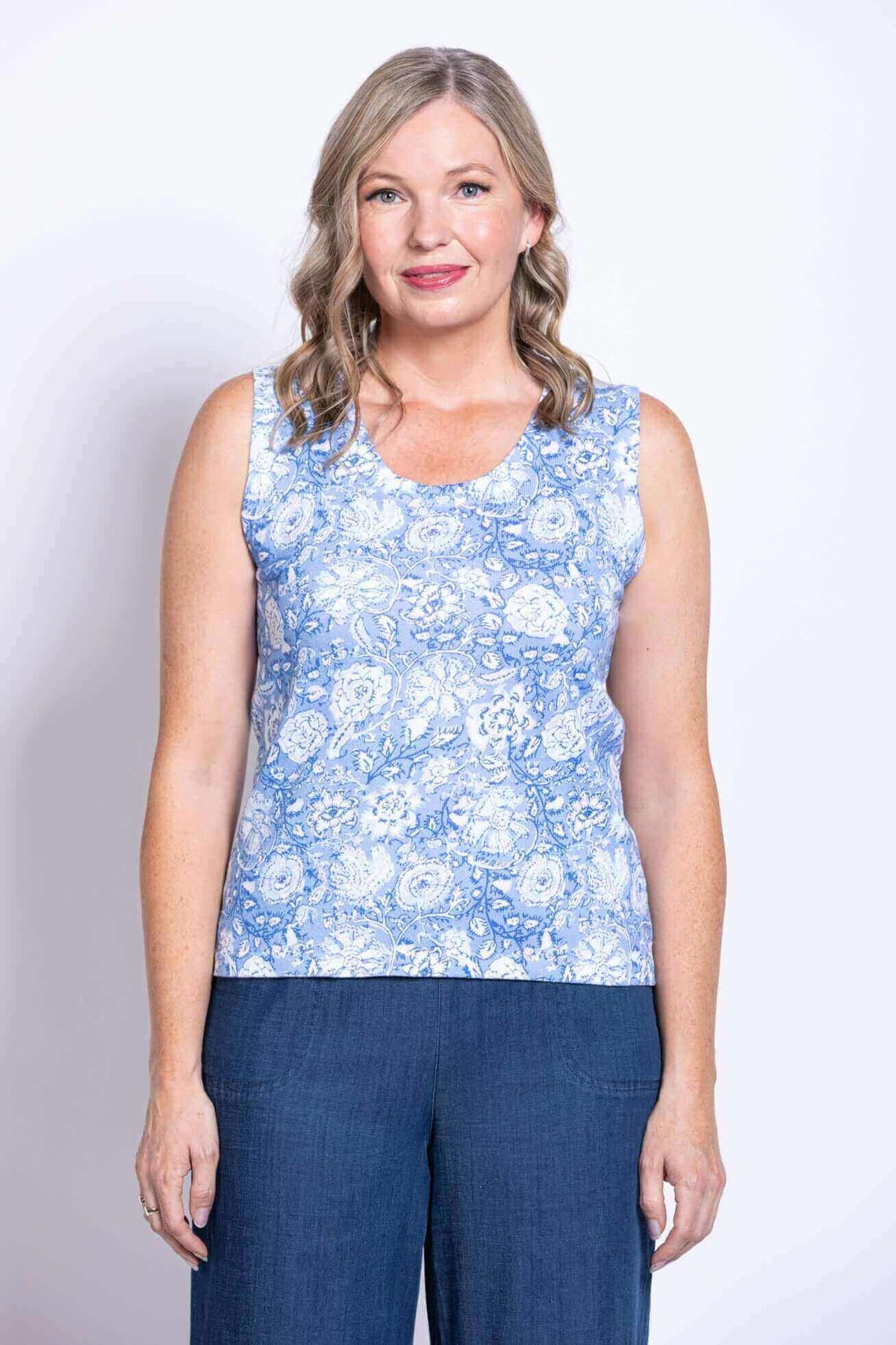 Close-up front view of woman in blue floral sleeveless tank top and blue pants