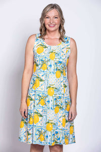 Close-up front view of woman in sleeveless lemon tile print dress