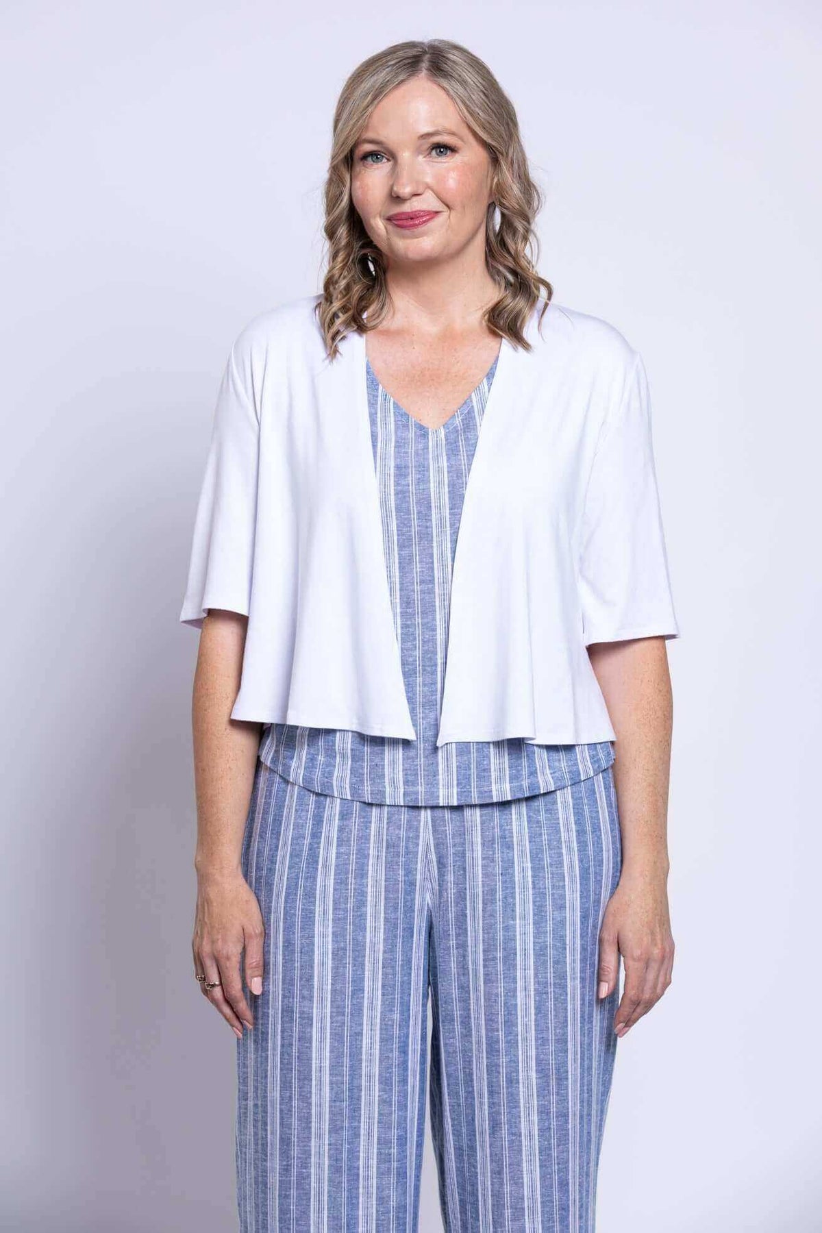 Close-up front view of woman in Landon cropped capri pants, matching top, and white cardigan