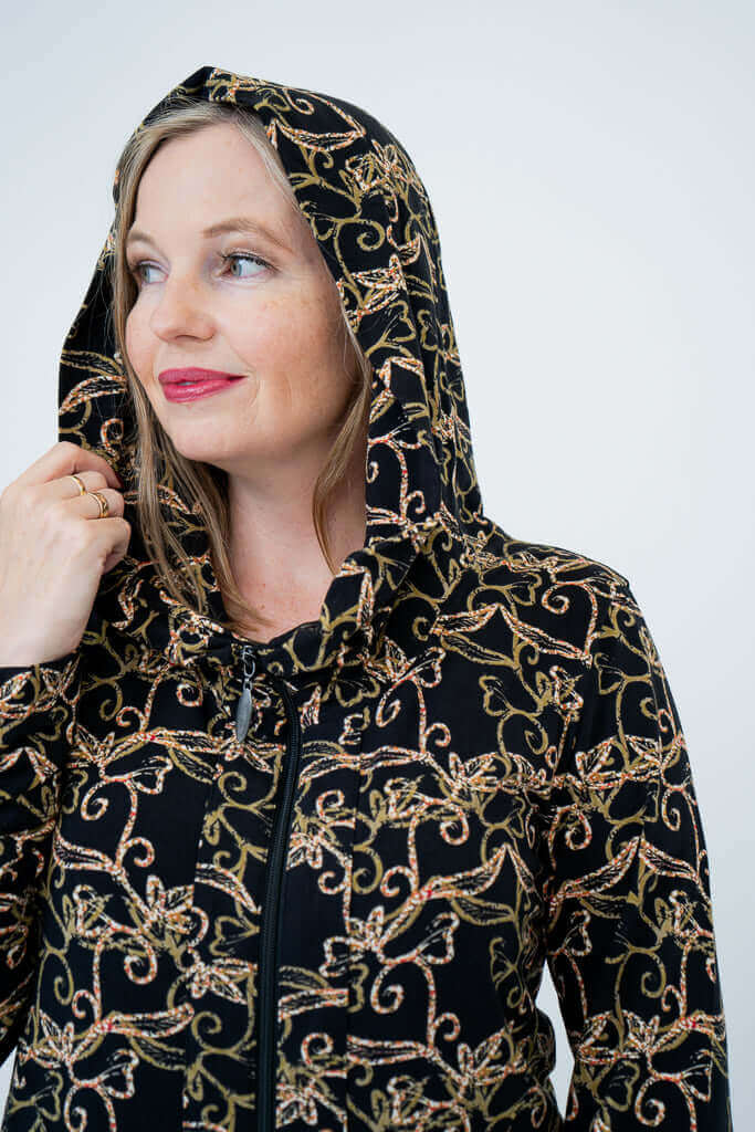 Close-up of a woman wearing the vine print hooded jacket with hood up