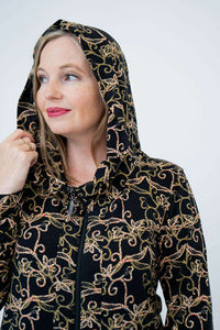 Close-up of a woman wearing the vine print hooded jacket with hood up
