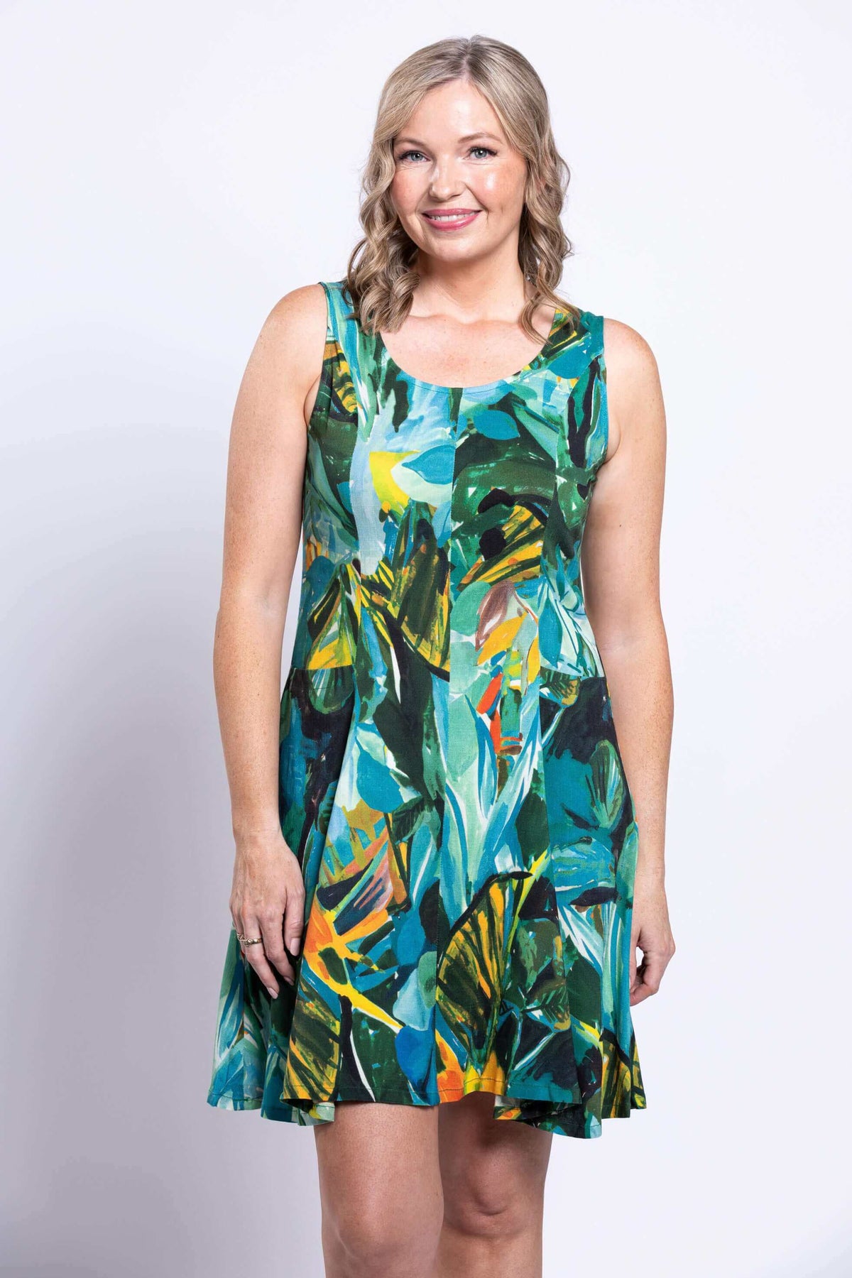 Close-up of woman in sleeveless bamboo linen dress featuring a colorful rainforest print
