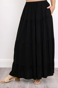 Close-up of the black tiered maxi skirt showing elastic waistband and pockets