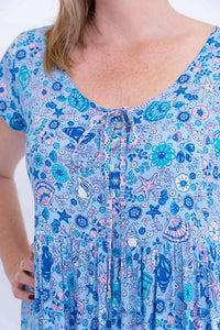 Close-up of bodice details with buttons and tie on blue floral dress