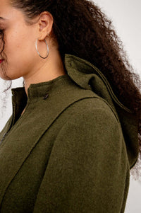 Close-up of buttoned detachable hood detail on olive green coat