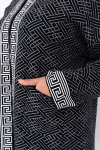 Detail of front pocket and bold geometric sleeve trim on black and white cardigan