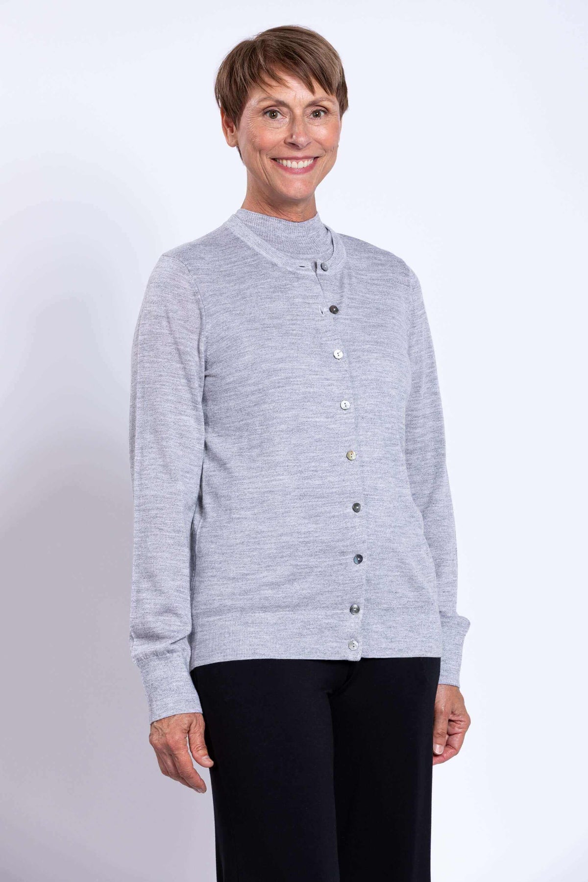 Close-up of a woman in a light grey merino wool crew neck cardigan