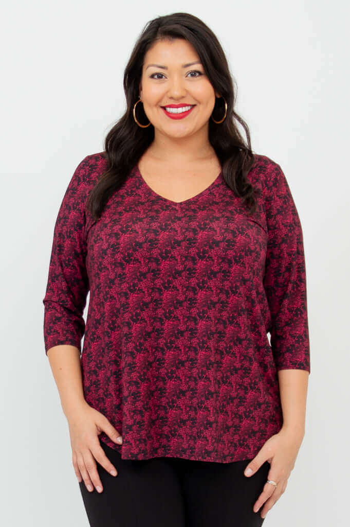 Close-up front view of model wearing coral print V-neck bamboo top with 3/4 sleeves