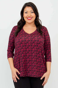 Close-up front view of model wearing coral print V-neck bamboo top with 3/4 sleeves