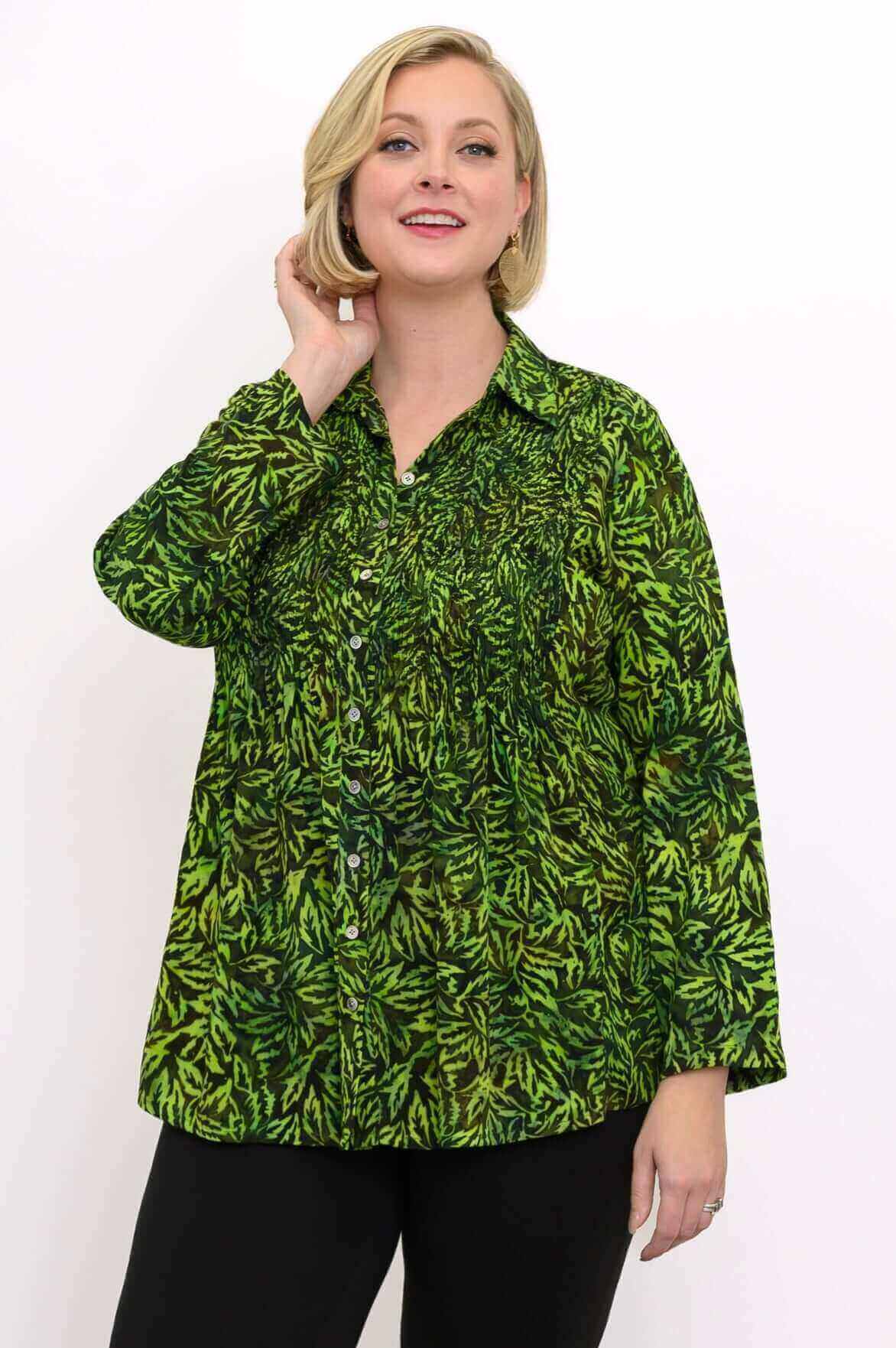 Woman wearing a green leaf print smocked top, close-up front view