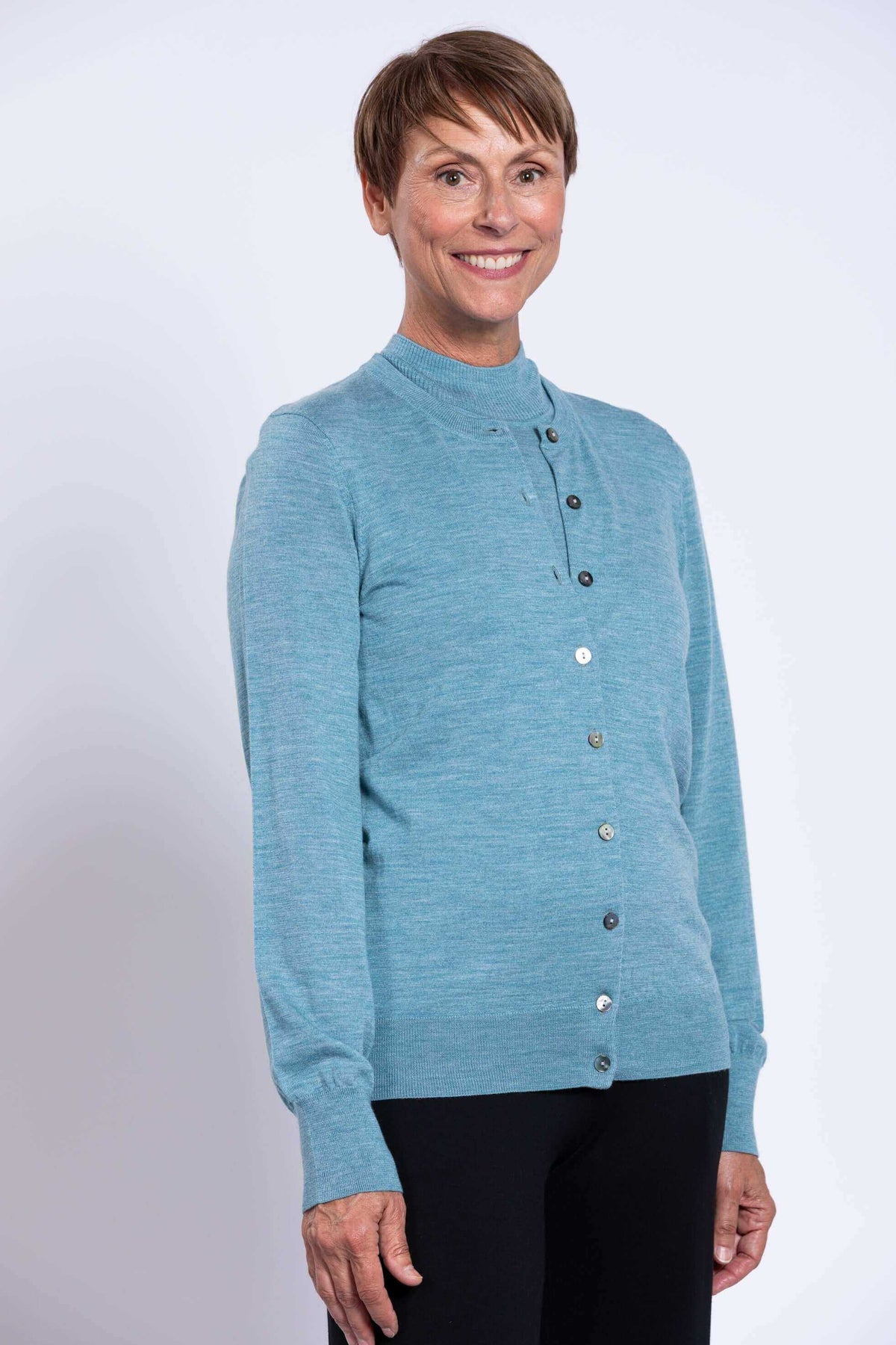 Close-up of woman in blue Merino wool cardigan, smiling
