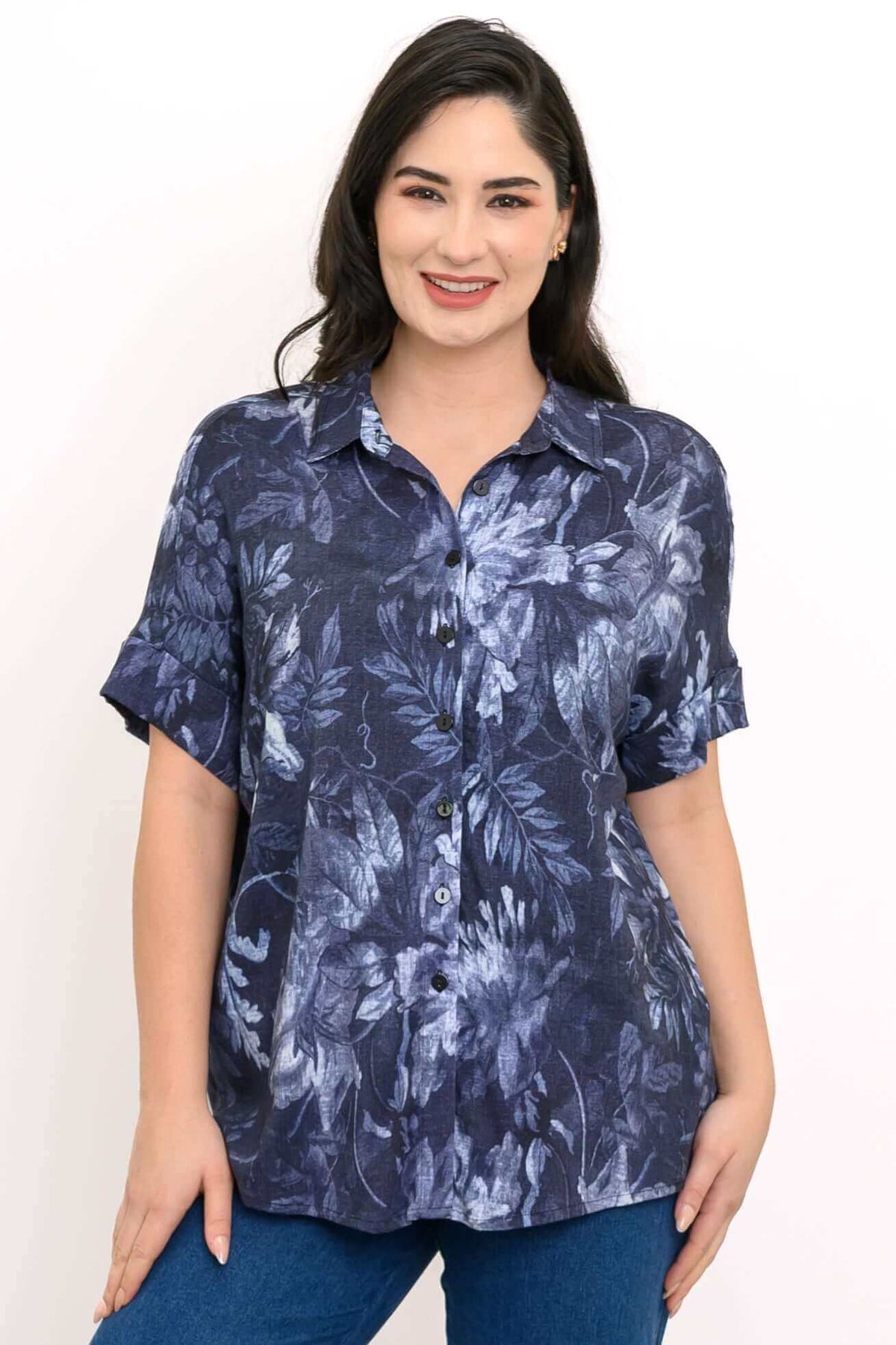 Close-up of a woman wearing a navy floral button-up blouse with dolman sleeves