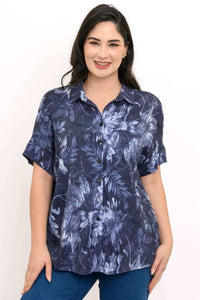 Close-up of a woman wearing a navy floral button-up blouse with dolman sleeves