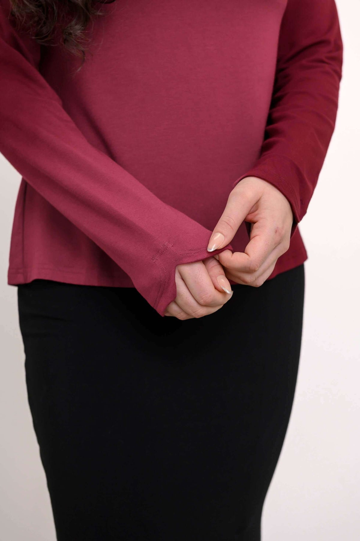 Close-up of sleeve and notched cuff detail on merlot boat neck top