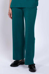 Front profile of a woman wearing deep teal green pull on lounge pants with a flat waistband in studio.