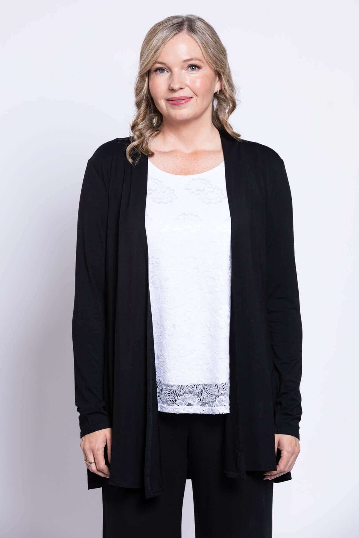 Close front view of woman in white lace tank top and black cardigan