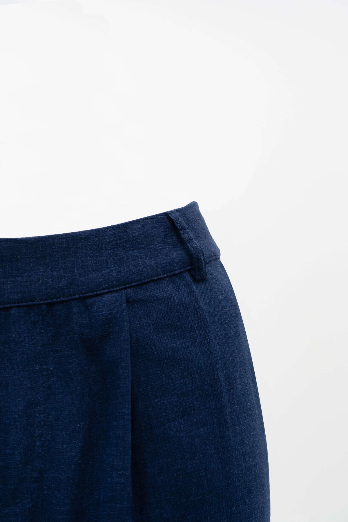 Close up of waistband and pleat details on navy Melodie pants