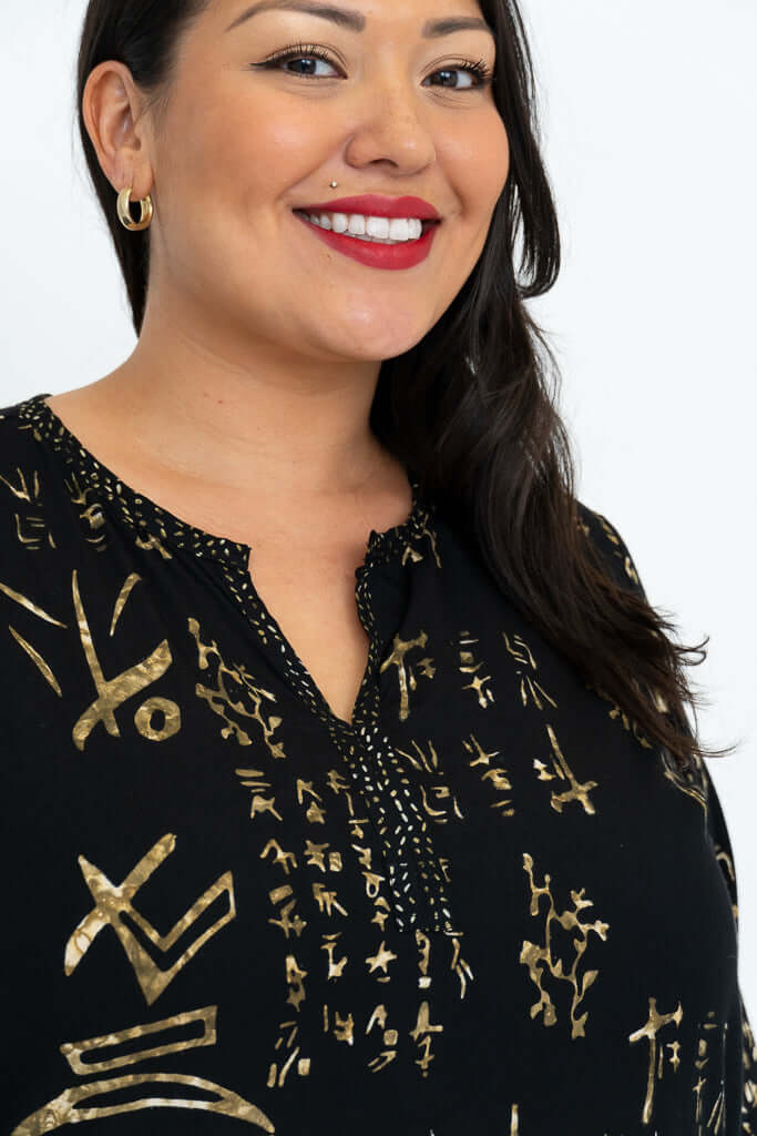 Close up of black blouse with gold batik pattern and detailed neckline