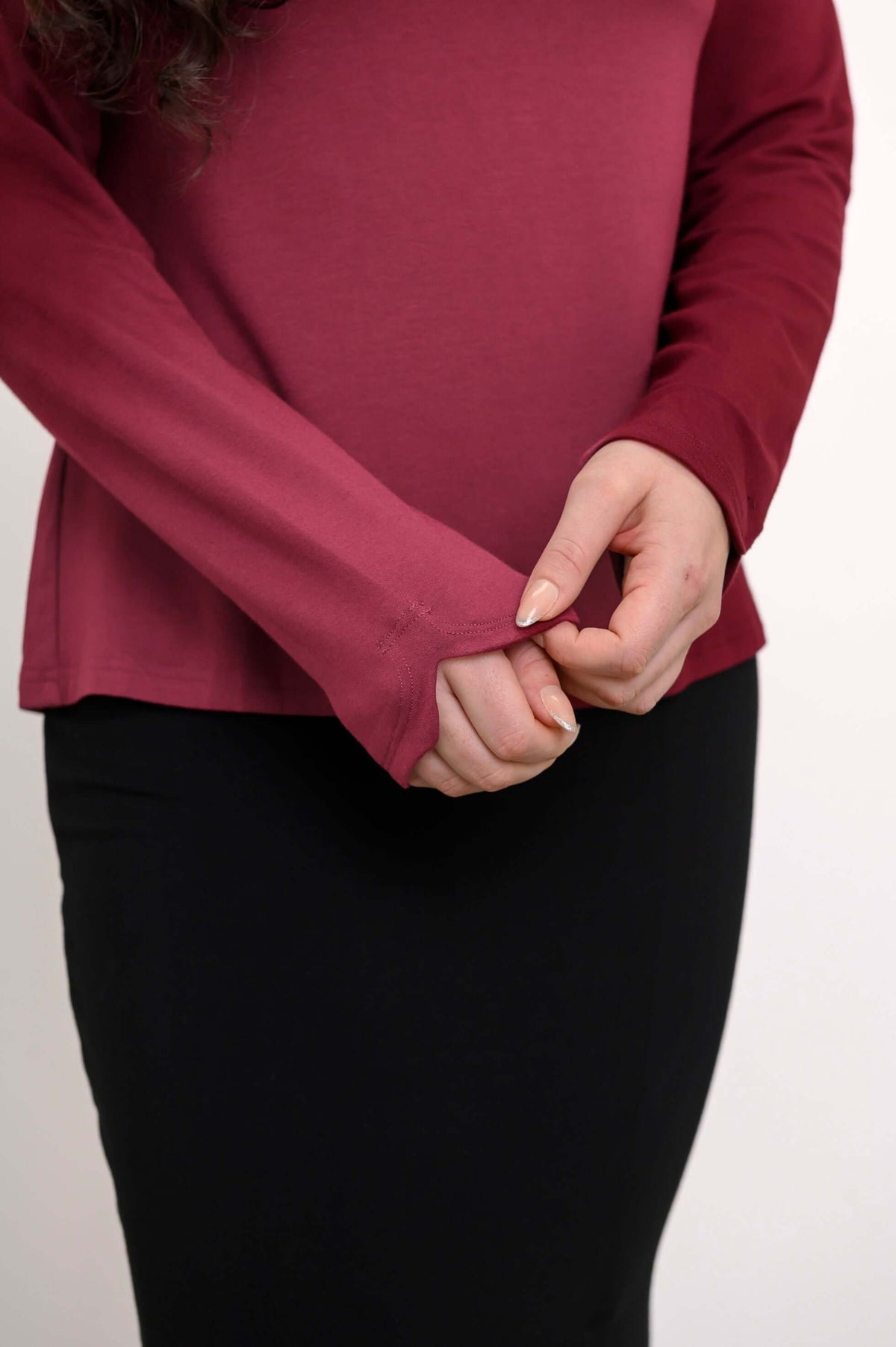 Closeup of maroon long sleeve top showing notched sleeve detail