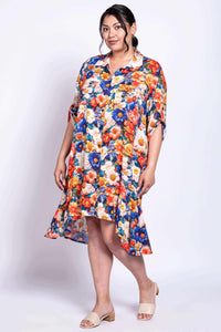 Model posing in a colorful floral Nora dress with pockets and tabbed sleeves