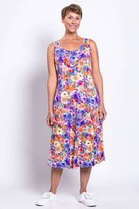 Woman wearing a colorful floral tank dress with a purple, orange, and cream pattern