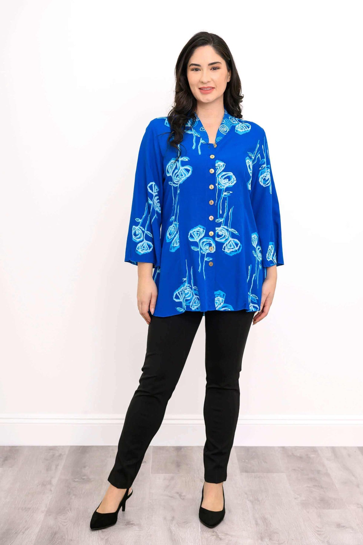 Full outfit view of woman wearing blue button-front blouse and heels