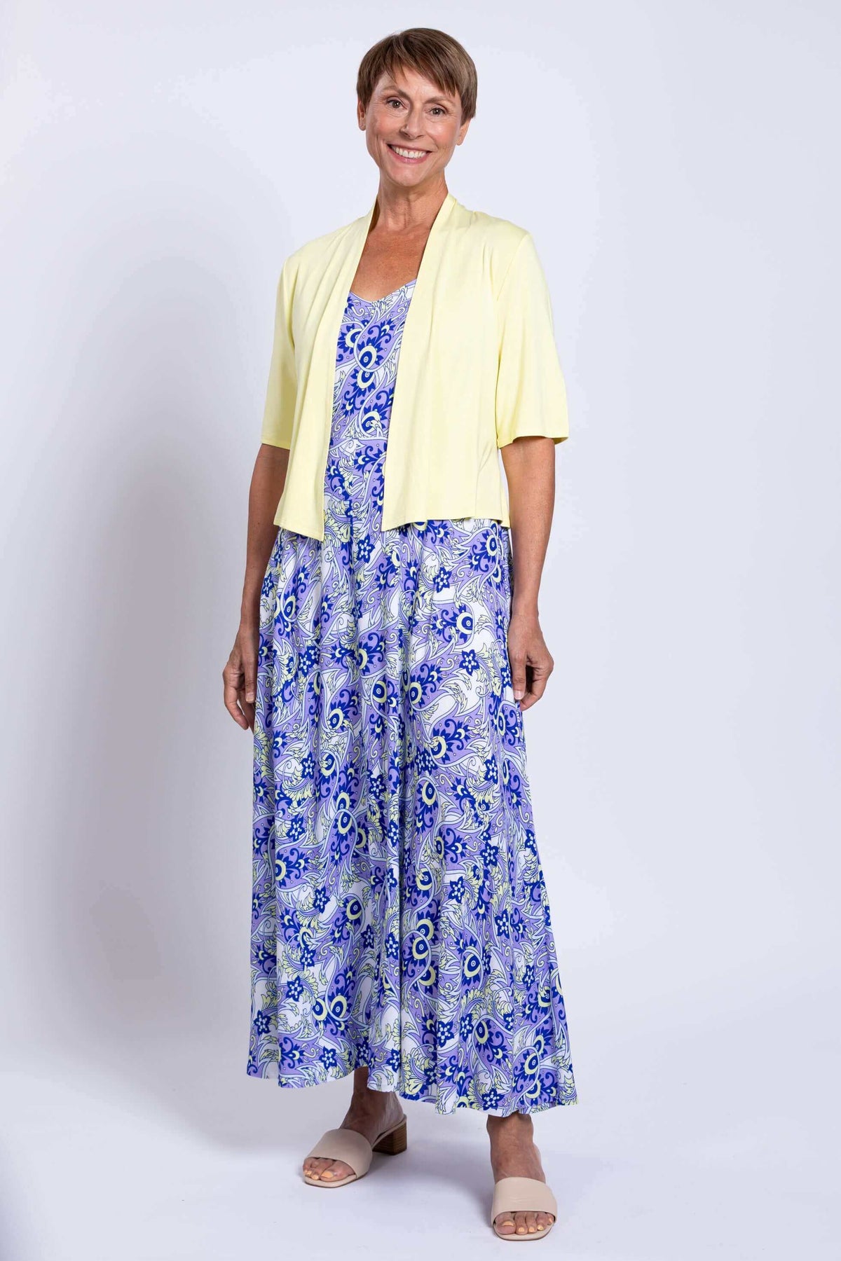 Woman layering the blue and white maxi dress with a short sleeve yellow cardigan