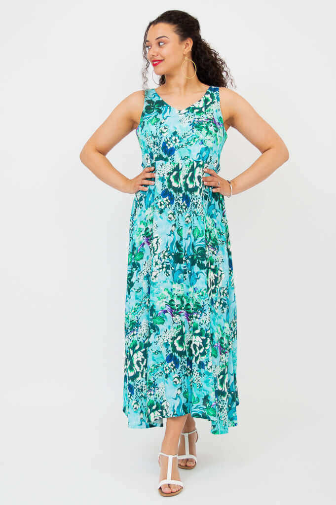 Model wears Coraline maxi dress in aqua floral, arms on waist