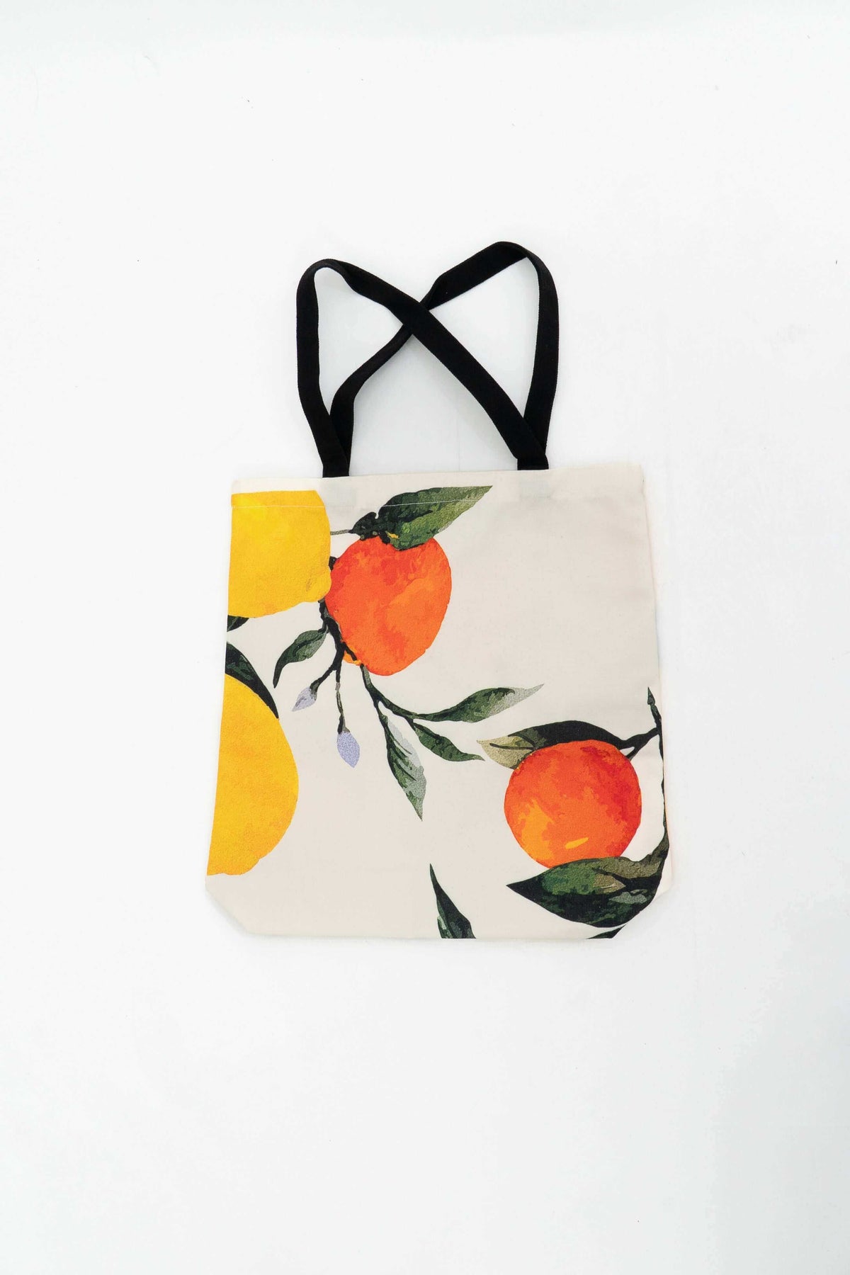 Cotton tote bag with orange and yellow citrus fruit print and black handles