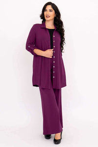 Woman with dark hair in a purple bamboo button-up tunic and wide leg pants