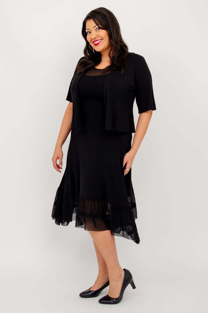 Side view of model in black mesh hem dress with black jacket