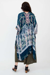 Woman wearing a Darcy kimono wrap over an olive dress, back view