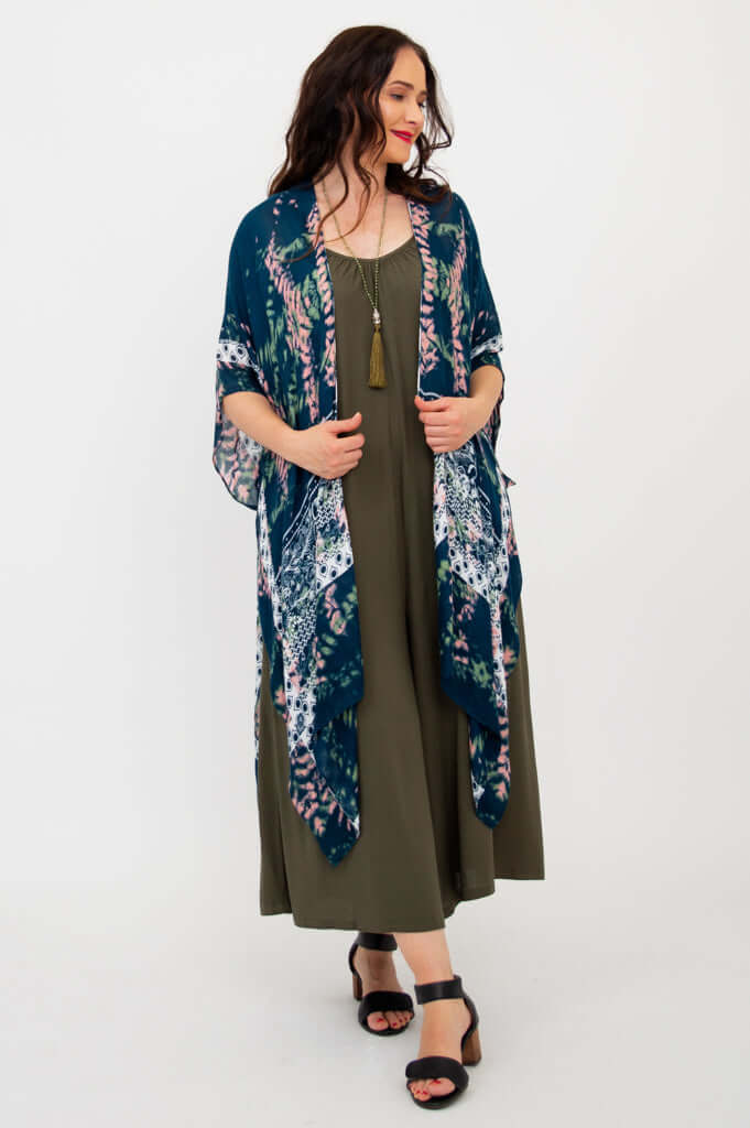 Woman wearing a Darcy kimono wrap over an olive dress, walking