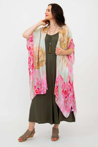 Woman posing in Darcy kimono wrap with vibrant floral pattern and olive jumpsuit