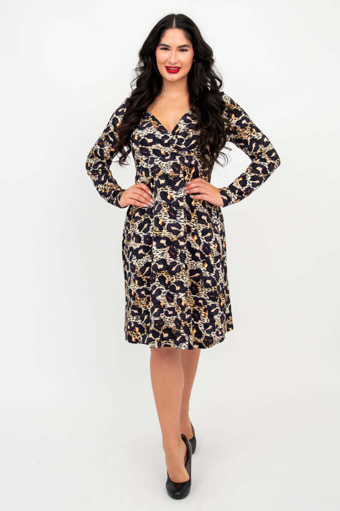 Woman with hands on hips modeling a leopard print empire waist dress