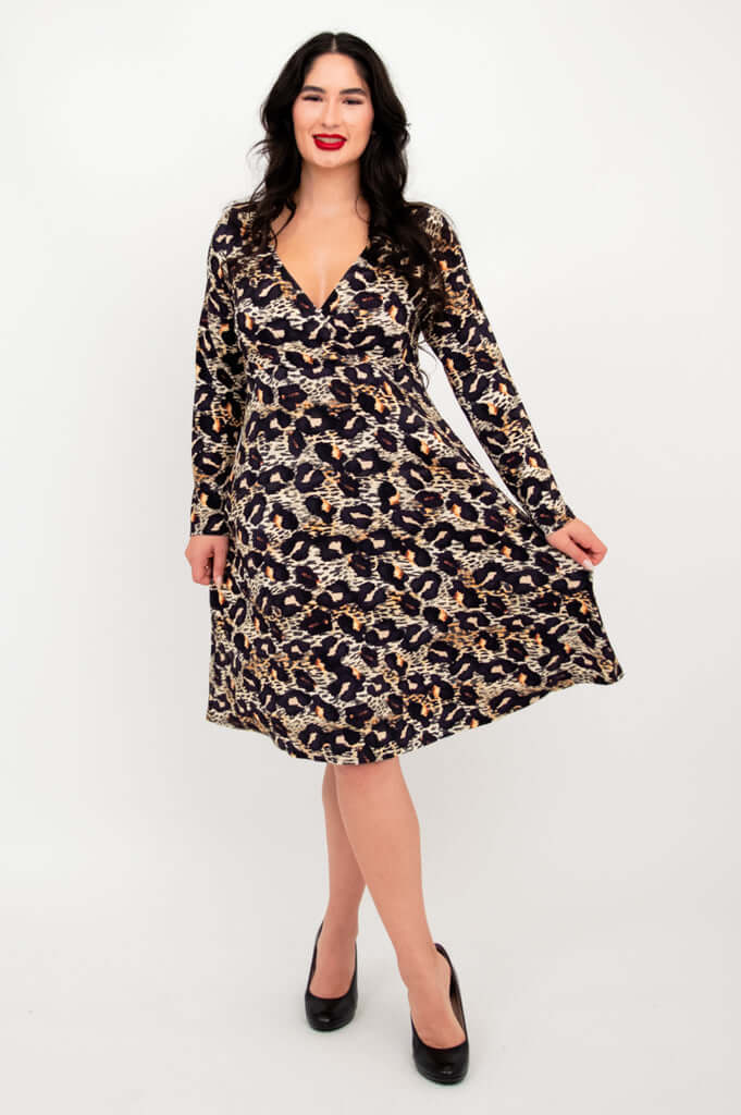 Woman showing the flowy skirt of a long-sleeve leopard print dress