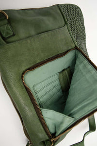 Detail of green leather bag's open front pocket with interior card slots