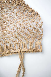 Close-up detail of the handwoven rattan bag’s mesh pattern and braided handles