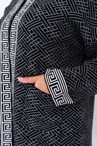 Detail of the front pocket and sleeve cuff with geometric pattern on a black cardigan