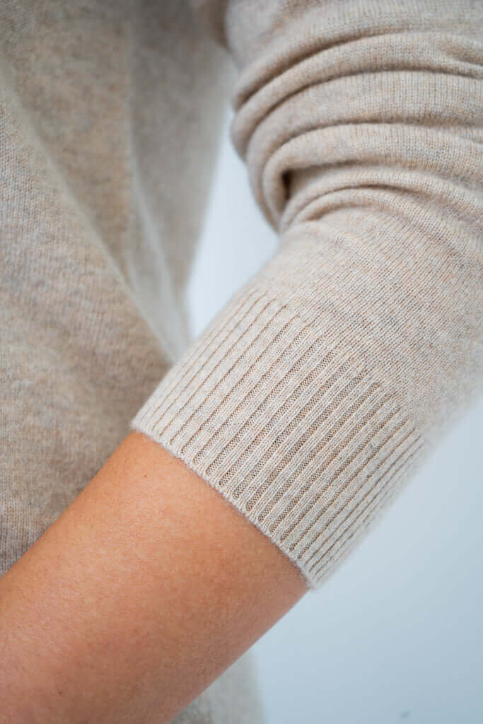 Detail of ribbed cuff on beige wool cashmere sweater sleeve