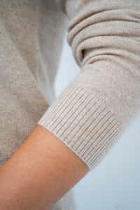 Detail of ribbed cuff on beige wool cashmere sweater sleeve