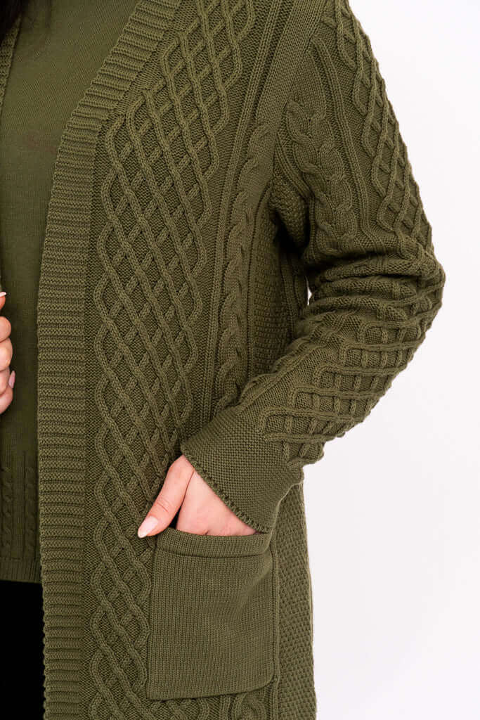 Close-up of the olive green cable knit cardigan's textured sleeve and patch pocket