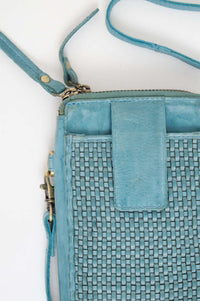 Close-up of woven leather texture and hardware on the azure wallet