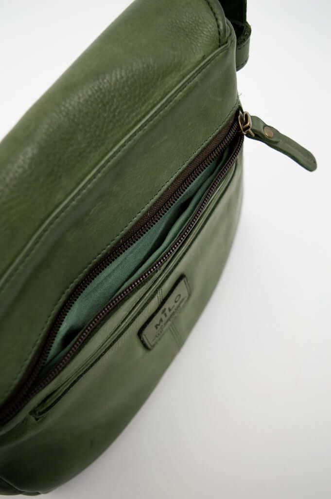 Close-up of the zippered front pocket and Milo leather label on the green bag
