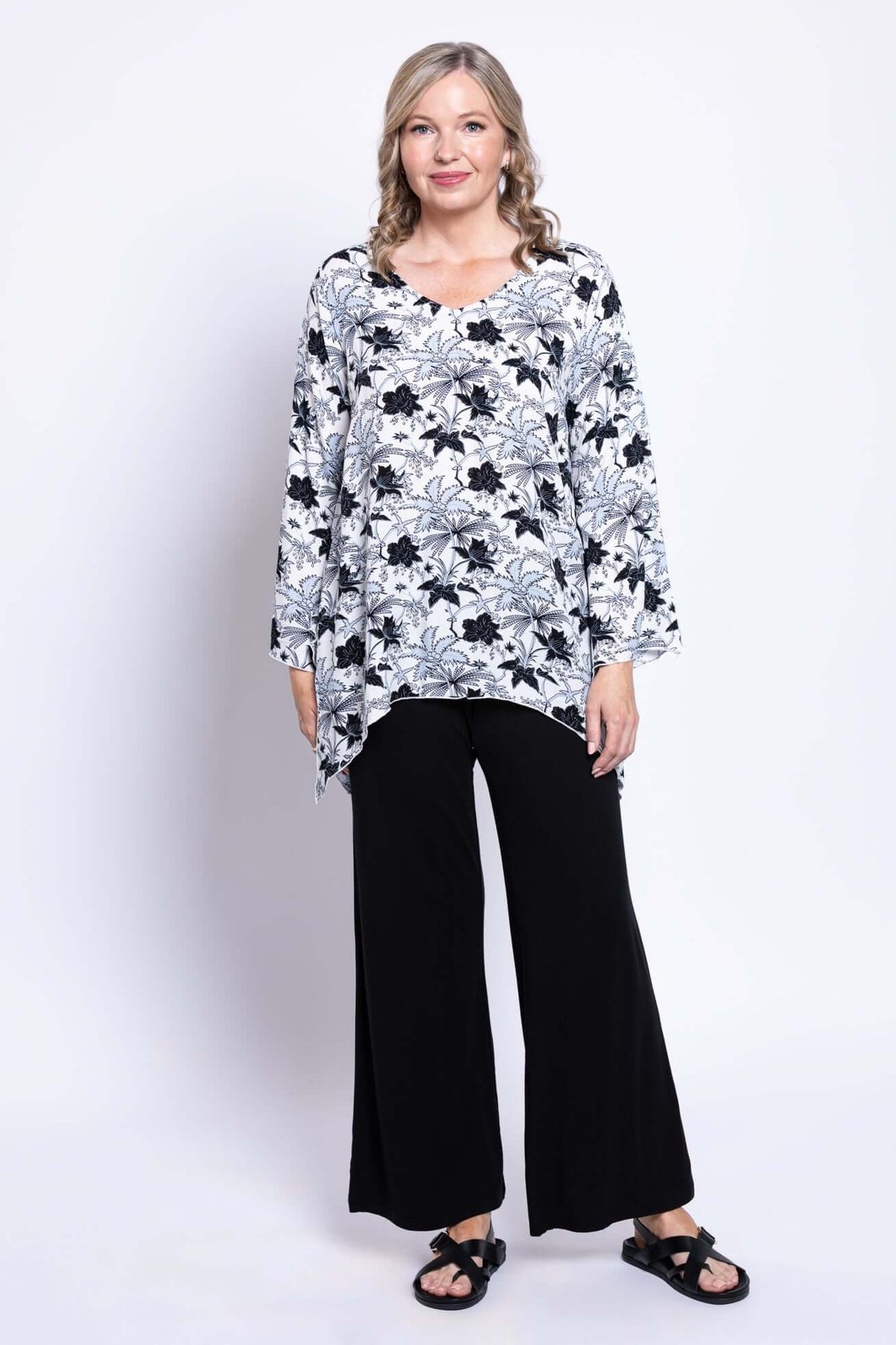 Angled front view of model in Dorothy top with V-neck, bell sleeves, and black pants