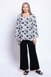 Angled front view of model in Dorothy top with V-neck, bell sleeves, and black pants
