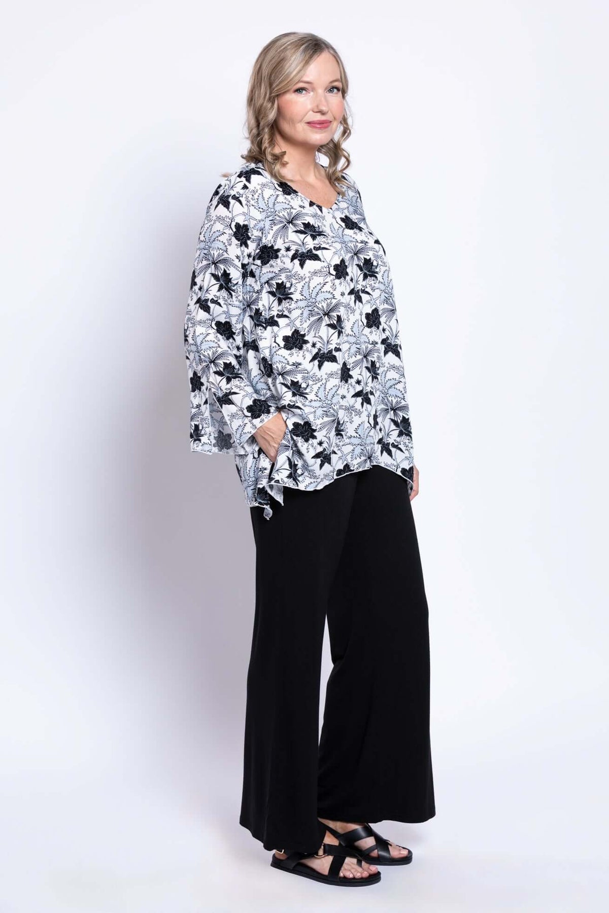 Side view of model in Dorothy floral bohemian top with relaxed fit and black pants