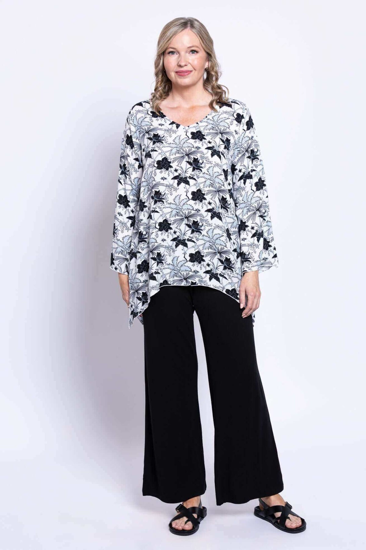 Woman modeling Dorothy bohemian flowy top with bell sleeves and shark-bite hem